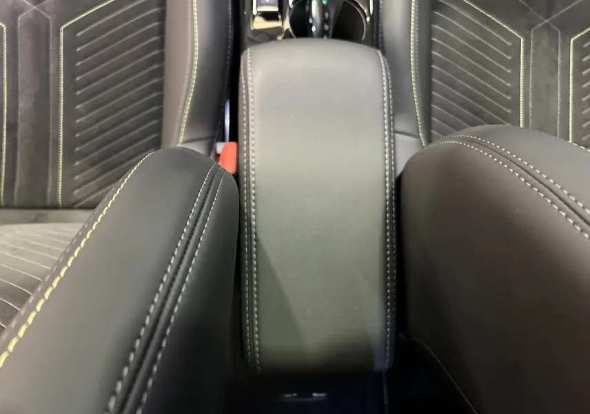 Vue rapprochée du coffre central en cuir noir avec surpiqûres contrastantes dans l’habitacle du Peugeot 2008 Hybrid 136 e-DCS6 GT.