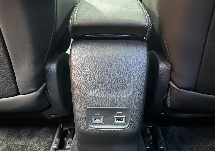 Vue rapprochée de la console centrale arrière noire du Peugeot 2008 Hybrid 136 e-DCS6 GT avec ports USB visibles entre les sièges.