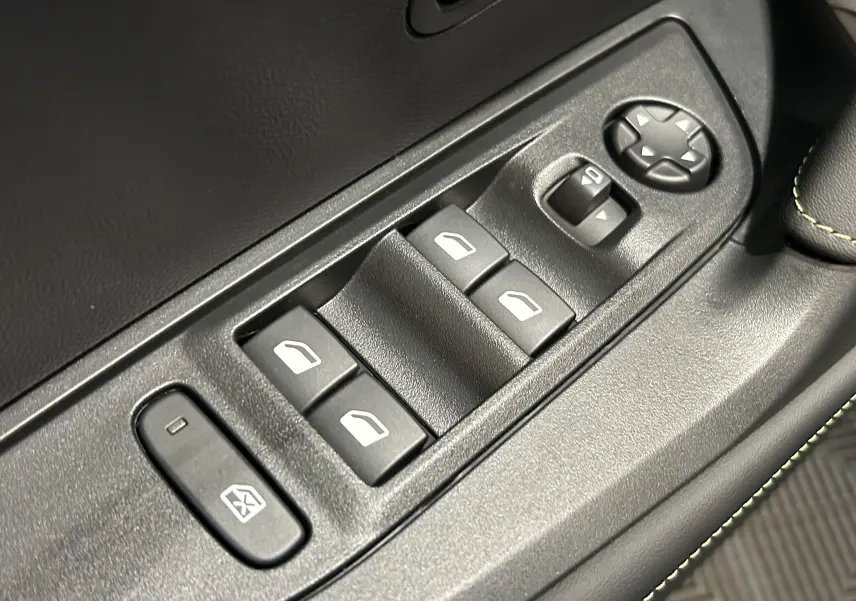 Gros plan sur les commandes de lève-vitres et réglages des rétroviseurs côté conducteur d’un Peugeot 2008 noir.