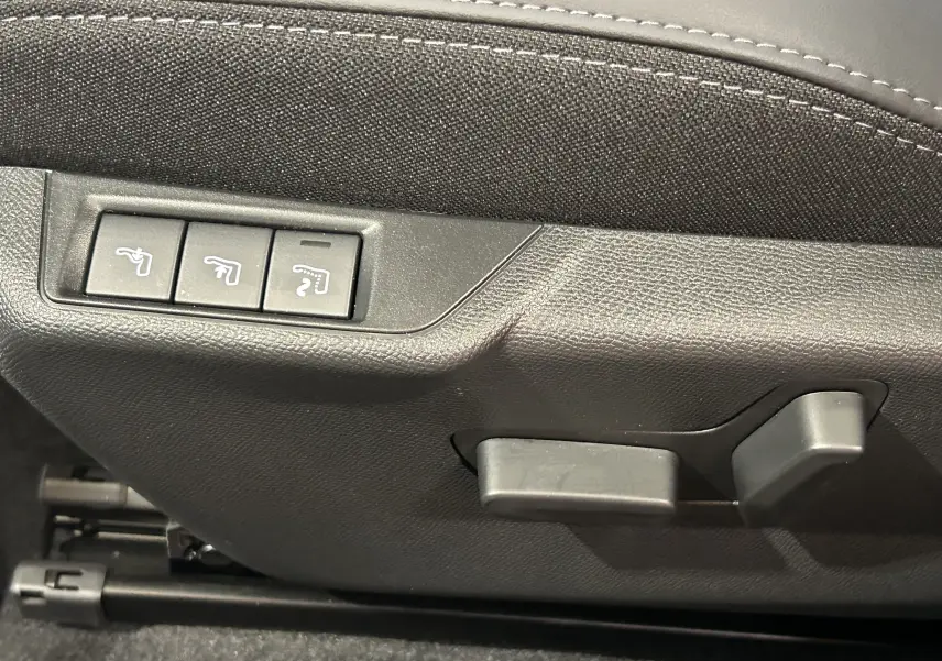 Détail des commandes de réglage électrique des sièges en cuir noir dans un Peugeot 2008 Hybrid 136 e-DCS6 GT.