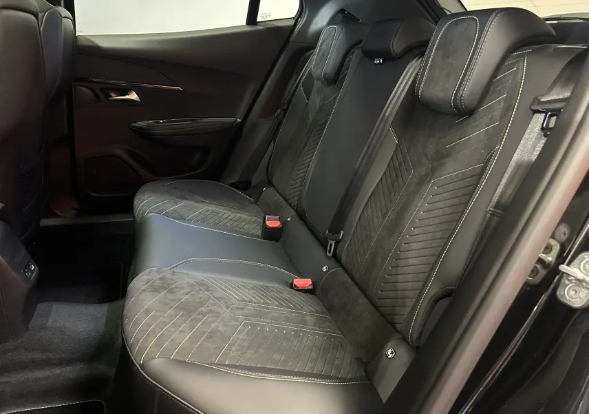 Vue intérieure côté droit des sièges arrière en cuir et alcantara noirs avec surpiqûres contrastées du Peugeot 2008 Hybrid 2025.