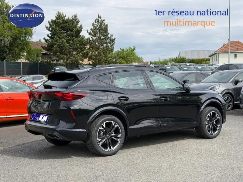Vue 3/4 arrière droite d'une CUPRA Formentor noire avec jantes alu distinctives sur parking multimarque.