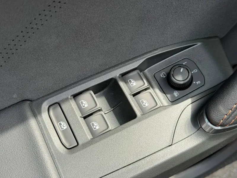 Gros plan sur les commandes de lève-vitres et réglage des rétroviseurs côté conducteur du CUPRA Formentor bleu 2026.