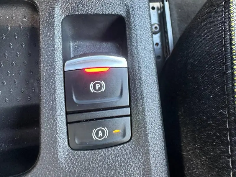 Gros plan sur la commande électronique du frein à main et du système start-stop du Renault Captur 2025, intérieur noir.