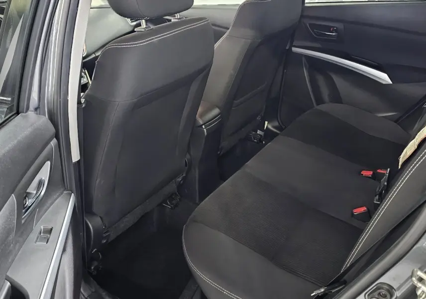 Vue intérieure arrière côté gauche du Suzuki SX4 S-Cross gris 2020, montrant les sièges noirs et les détails de la portière.