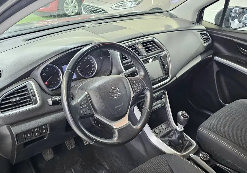 Intérieur du Suzuki SX4 S-Cross gris 2020, vue côté conducteur sur le tableau de bord et levier de vitesse manuel.