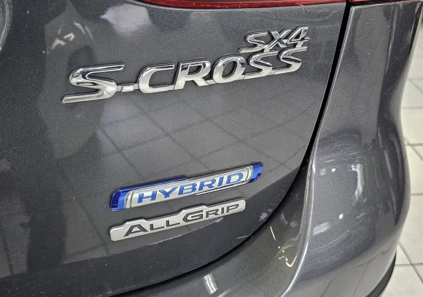 Gros plan sur l'arrière gris du Suzuki SX4 S-Cross avec badges Hybrid et AllGrip visibles.