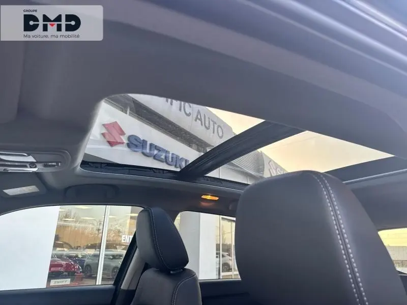 Vue intérieure du Suzuki Vitara 1.4 Boosterjet Hybrid avec toit panoramique en verre et sièges en suédine noire.
