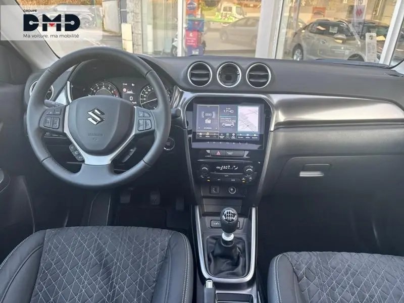 Vue intérieure avant du Suzuki Vitara 1.4 Boosterjet Hybrid 2026, volant cuir multifonction et écran tactile central.