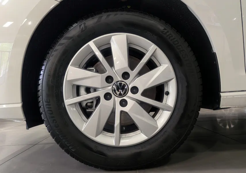 Gros plan sur la roue avant droite blanche d'un Volkswagen Caddy 2.0 TDI 2025 avec jante alliage et pneu Bridgestone.