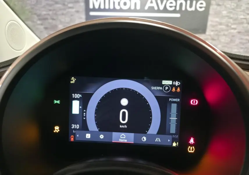Vue rapprochée du tableau de bord numérique de la Fiat 500 Cabriolet électrique rose, affichant 0 km/h et l'autonomie restante.