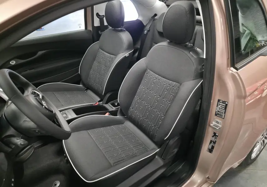 Vue intérieure côté conducteur de la FIAT 500 Cabriolet électrique rose, avec sellerie noire et volant soft-touch.