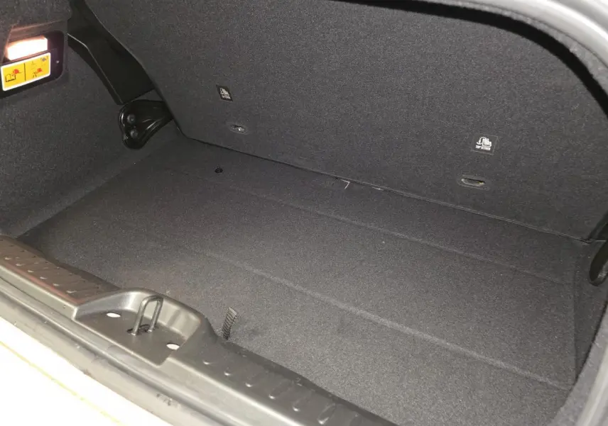 Vue rapprochée de l'intérieur du coffre noir d'une Fiat 500 Cabriolet électrique 2023, sans chargement visible.