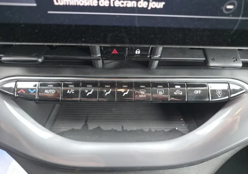 Vue rapprochée des commandes de climatisation automatique sur la planche de bord grise du Fiat 500 Cabriolet électrique rose.