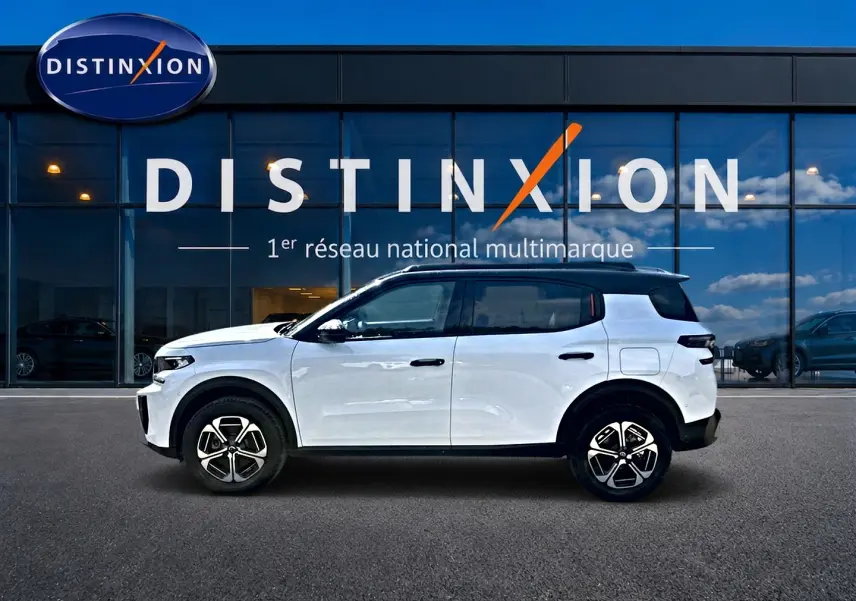 Profil côté gauche d'un Citroën C3 Aircross blanc avec toit noir, jantes alu et détails noirs contrastants.