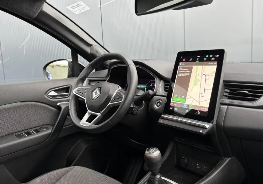 Vue intérieure côté conducteur du Renault Captur 2025 avec tableau de bord numérique et écran tactile vertical.