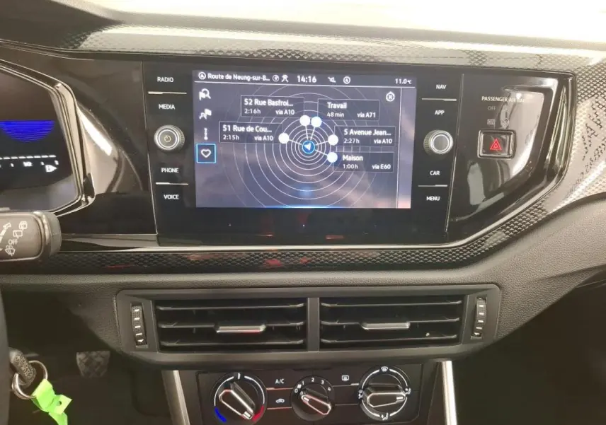 Tableau de bord de Volkswagen Polo 2023 avec écran tactile GPS, commandes climatisation et finition noire brillante.