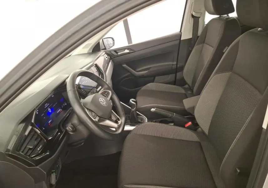 Vue intérieure côté conducteur de la Volkswagen Polo 2023 avec sièges tissu gris et tableau de bord numérique.