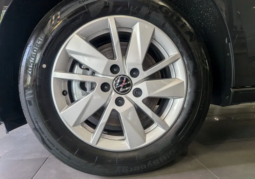 Gros plan sur la jante alliage argentée du Volkswagen Caddy noir 2025, mettant en valeur le logo VW central.