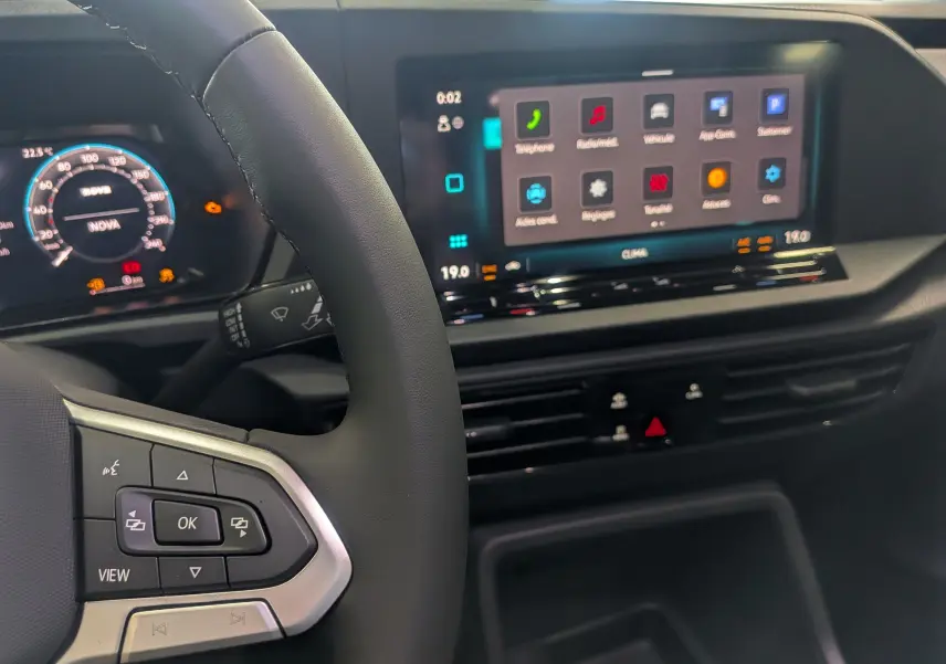 Vue intérieure du tableau de bord et volant du Volkswagen Caddy 2.0 TDI 2025 avec écran tactile et commandes au volant.