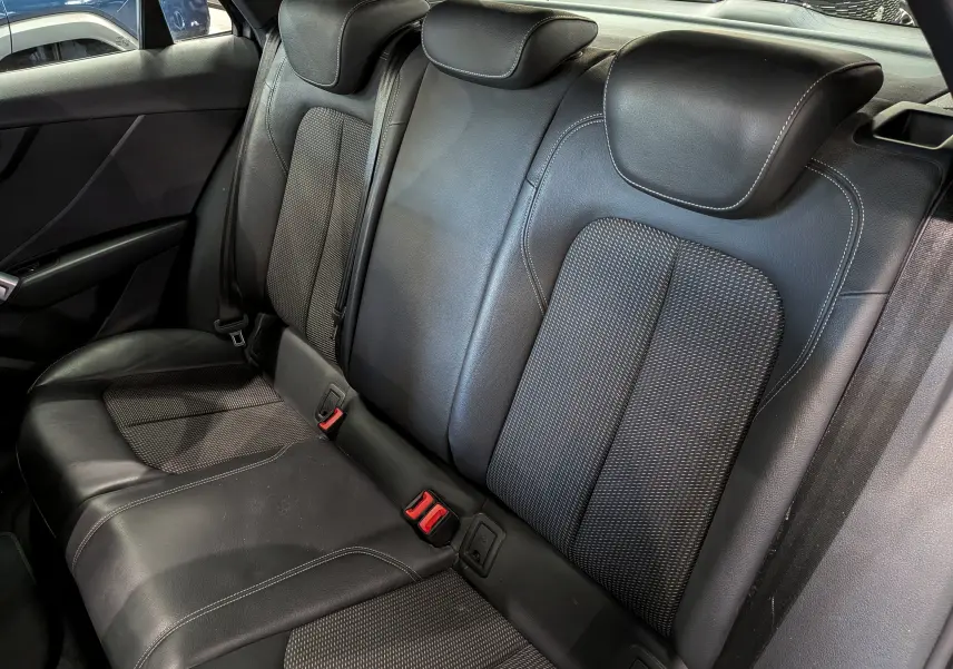 Vue intérieure sur la banquette arrière en cuir noir avec surpiqûres blanches de l'Audi Q2 gris 2017.