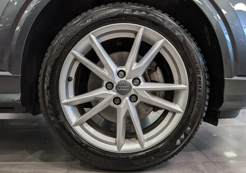 Gros plan sur la roue avant droite d’un Audi Q2 gris 2017, avec jante alliage 18 pouces à 10 branches.
