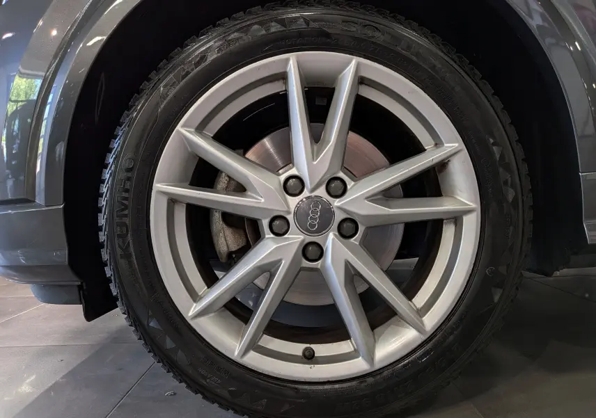 Gros plan sur la roue avant gauche grise d’un Audi Q2 1.4 TFSI S-Line, avec jante en alliage à 5 doubles branches.
