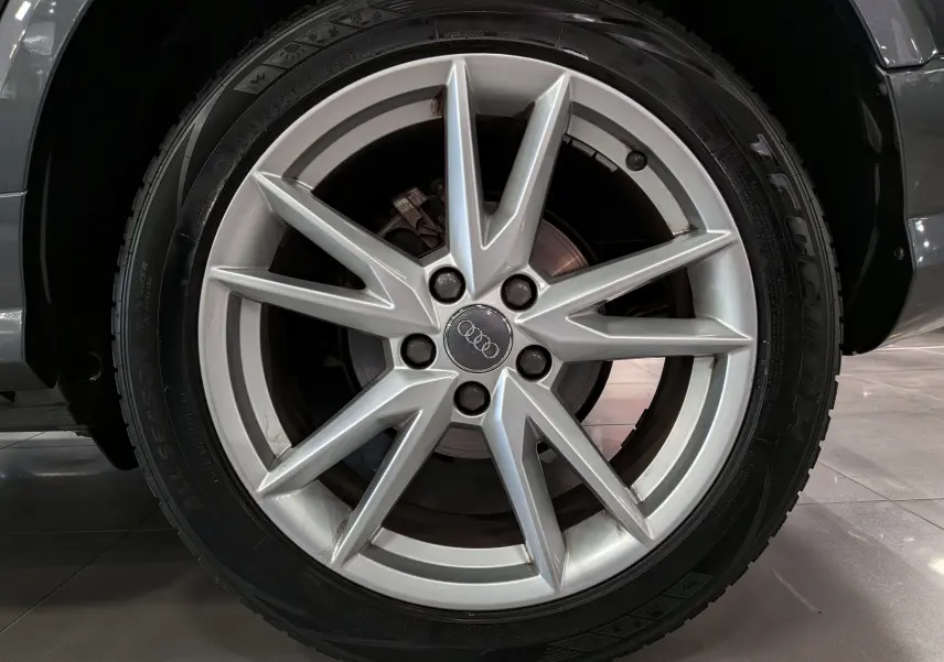 Gros plan sur la jante argentée à dix branches de l'Audi Q2 gris, mettant en valeur le logo Audi au centre.