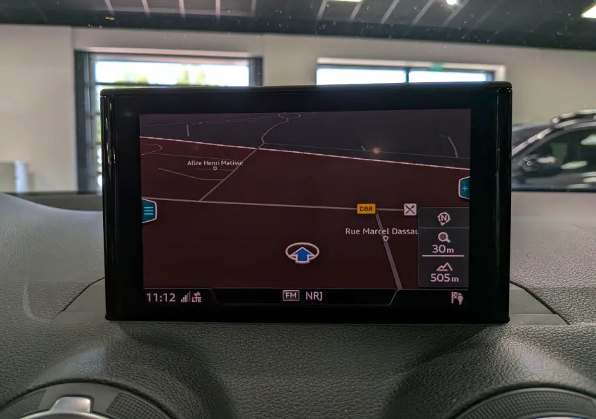 Écran central du système de navigation de l’Audi Q2 2017 affichant une carte avec itinéraire en intérieur gris.