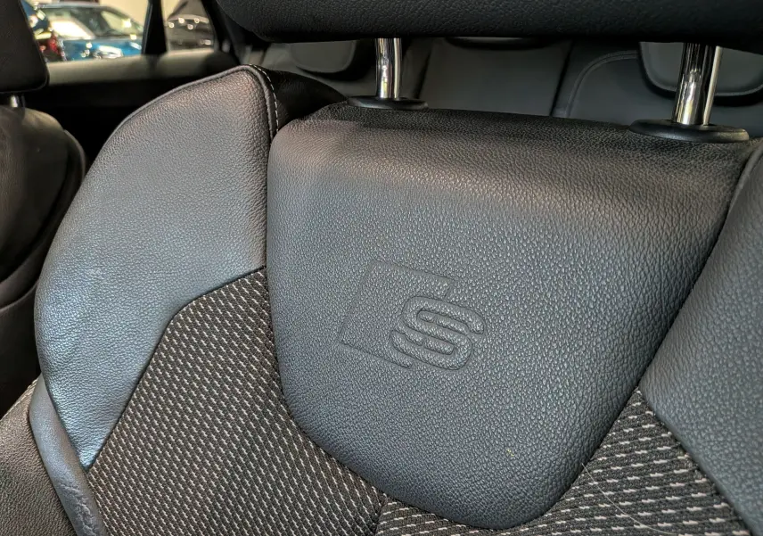 Gros plan sur l'appui-tête en cuir noir embossé du logo S de l'Audi Q2 gris, version S-Line 2017.