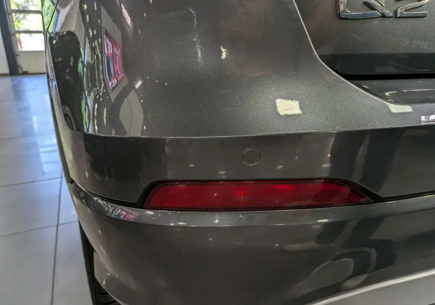Détail du feu arrière droit gris métallisé d’un Audi Q2 1.4 TFSI S-Line de 2017 avec capteur de recul intégré.