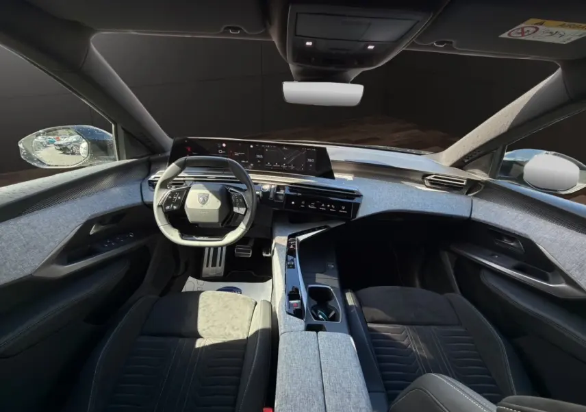 Vue intérieure avant du Peugeot 5008 2025 avec finition Alcantara gris clair et tableau de bord numérique large.