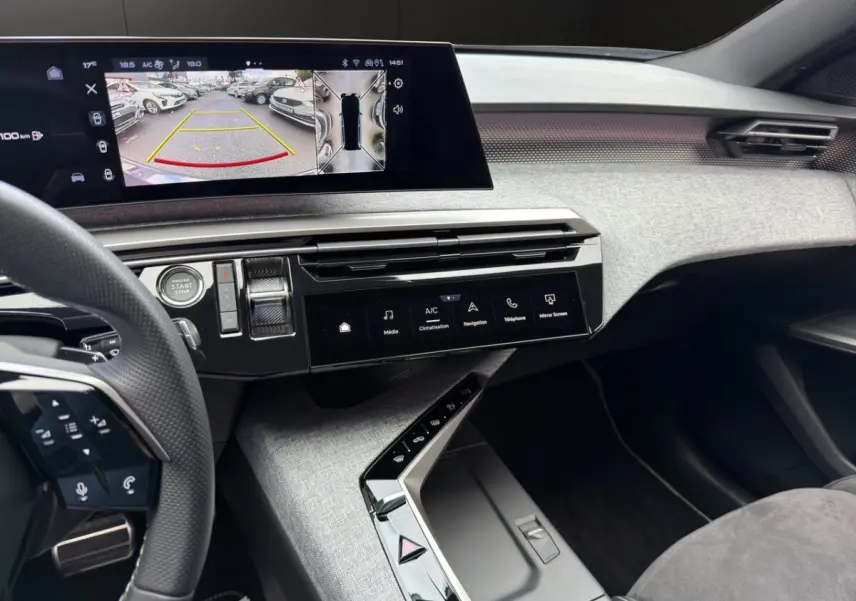 Vue intérieure du tableau de bord du Peugeot 5008 gris foncé, avec écran tactile multifonctions et volant cuir multifonction.