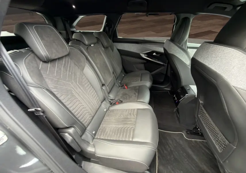 Vue intérieure côté gauche sur la banquette arrière en Alcantara gris foncé du Peugeot 5008 2025 hybride.
