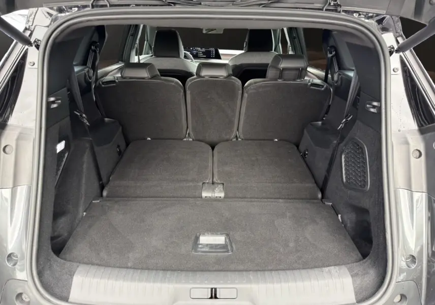 Coffre ouvert du Peugeot 5008 gris foncé, vue arrière montrant la 3ème rangée de sièges rabattue à plat.