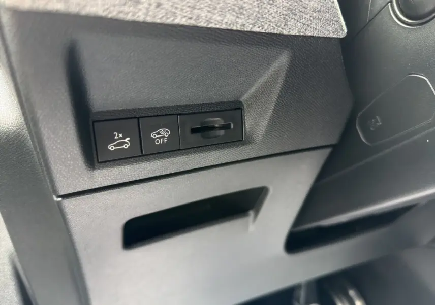 Gros plan sur les commandes de coffre et désactivation du système, intérieur noir du Peugeot 5008 hybride 2025.
