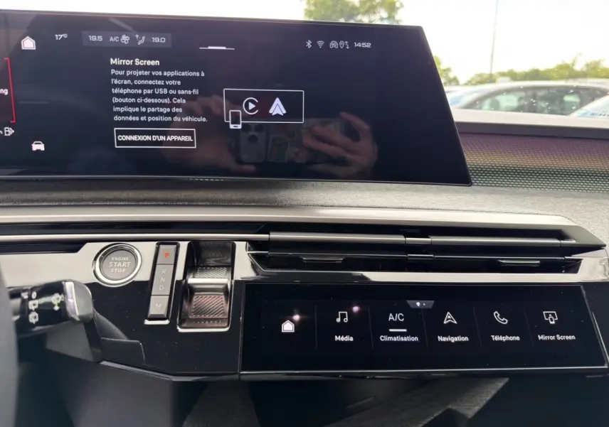 Vue intérieure du tableau de bord du Peugeot 5008 2025, avec écran tactile large et commandes modernes en noir brillant.