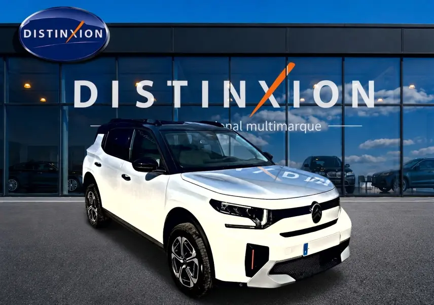 Citroën C3 Aircross blanc vue 3/4 avant droit avec toit noir et jantes alu devant un showroom Distinxion.