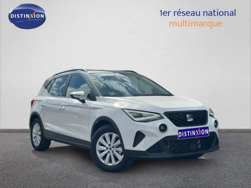 SEAT Arona blanc Candy avec toit gris Magnétique, vue 3/4 avant droit, jantes alu et calandre noire distinctive.