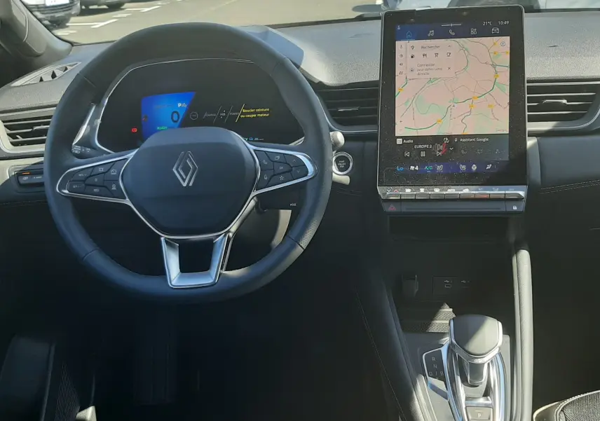 Vue intérieure du tableau de bord du Renault Symbioz gris cassiopée, avec volant multifonctions et écran tactile central vertical.