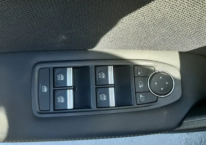 Panneau de commandes des vitres et rétroviseurs côté gauche dans l'habitacle du Renault Symbioz gris Cassiopée.