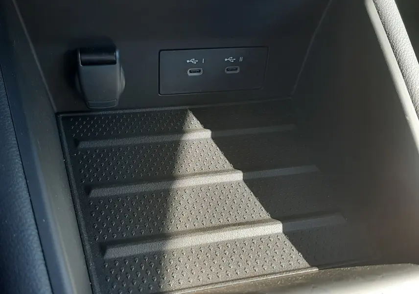 Gros plan sur la console centrale noire du Renault Symbioz 2025 avec deux ports USB-C intégrés et surface antidérapante.