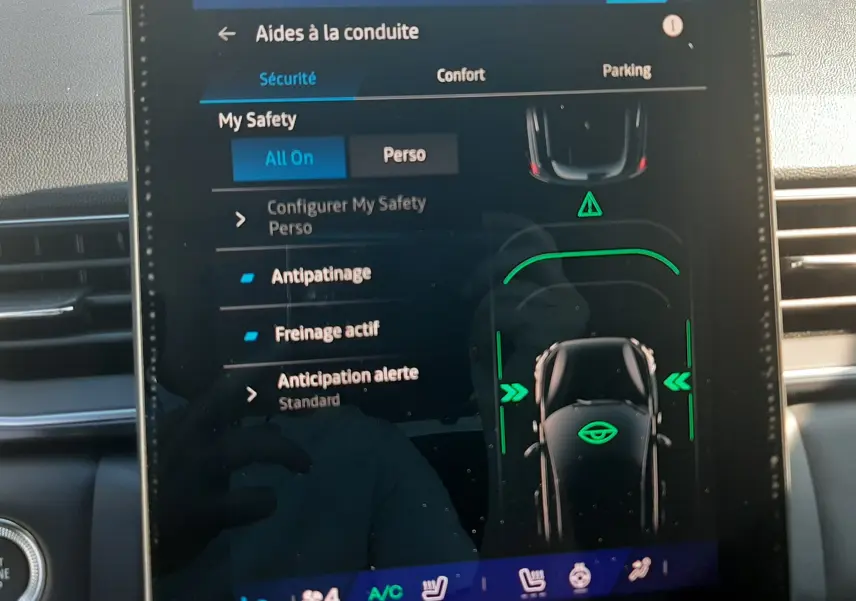 Écran tactile central du Renault Symbioz 2025 affichant les aides à la conduite avec interface moderne et détails verts lumineux.