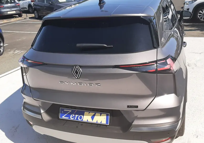 Vue 3/4 arrière du Renault SYMBIOZ gris cassiopée avec feux LED fins et logo central bien visible.