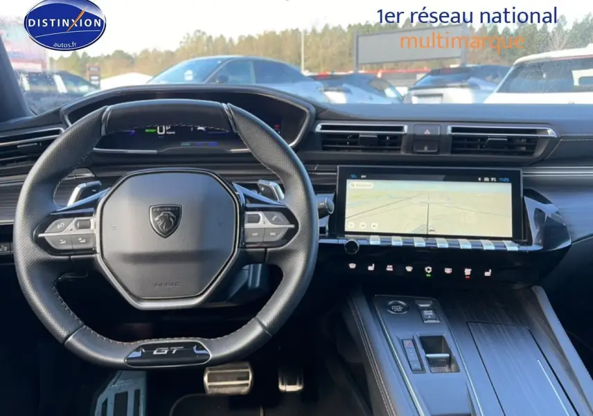 Vue intérieure du tableau de bord de la Peugeot 508 Hybrid 225 GT gris titane, avec volant GT et écran tactile GPS.