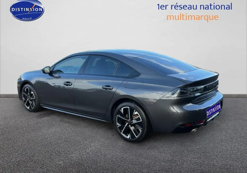 Vue 3/4 arrière droite d'une Peugeot 508 Hybrid 225 GT gris titane avec jantes alu et feux arrière LED.