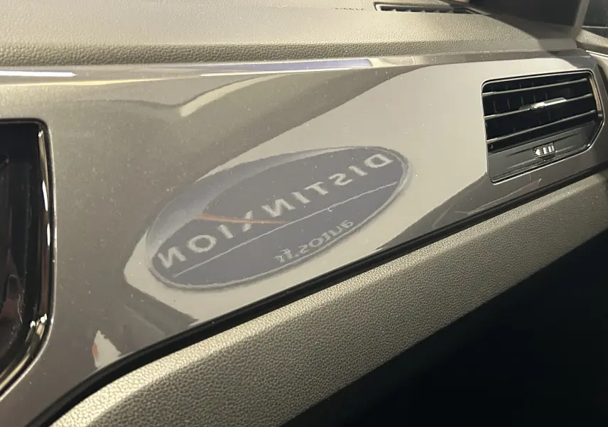 Gros plan sur la planche de bord grise brillante côté passager de la Volkswagen Polo 2018 avec une grille d'aération noire.