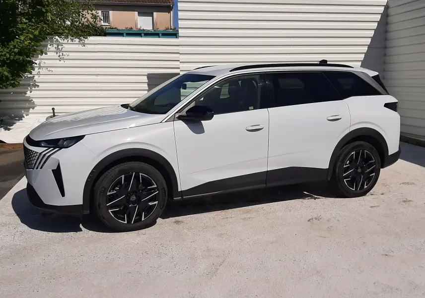 Peugeot 5008 hybride blanc Okenite vue de profil côté gauche, avec jantes noires et toit noir contrasté.