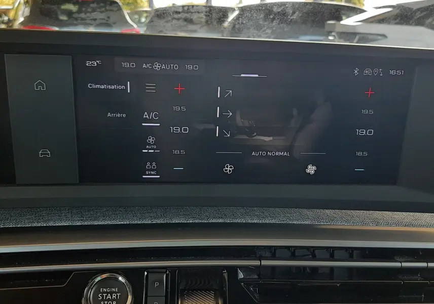 Écran tactile central affichant la climatisation et la boîte auto, intérieur noir du Peugeot 5008 Hybrid blanc Okenite.