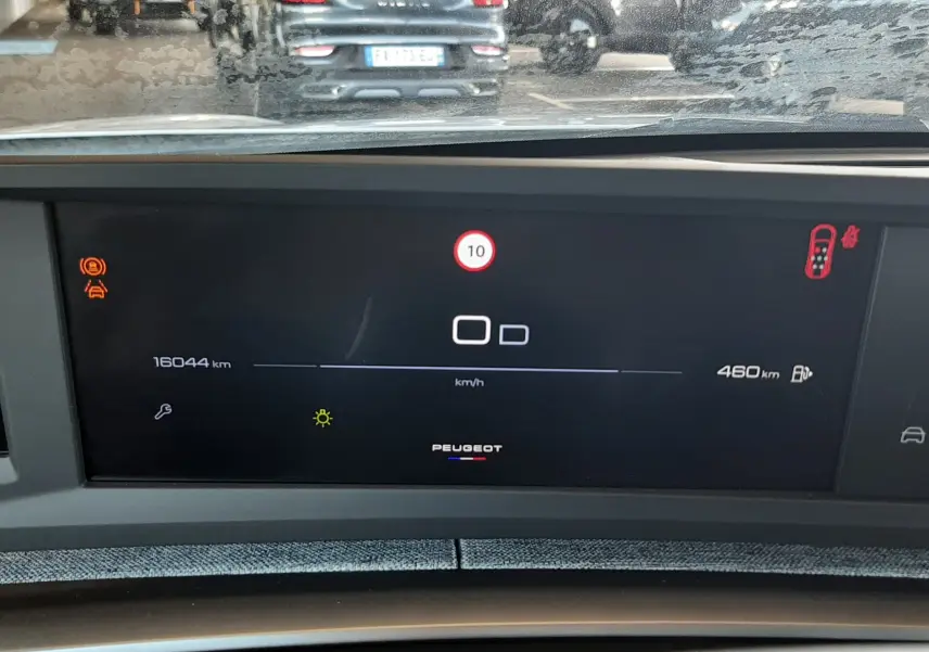 Tableau de bord numérique du Peugeot 5008 hybride 2025, affichant la vitesse et l'autonomie, vue intérieure frontale.